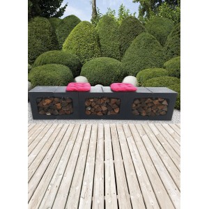 Anthrazitfarbener Beton U-Stein als Bank mit Kaminholzfach und pinken Kissen im Garten.