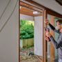 Mann arbeitet mit Einhell Multitool-Set XL an einem Fensterrahmen.