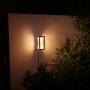 Philips Hue Impress Wandleuchte, schwarz, warmweißes Licht im Garten.