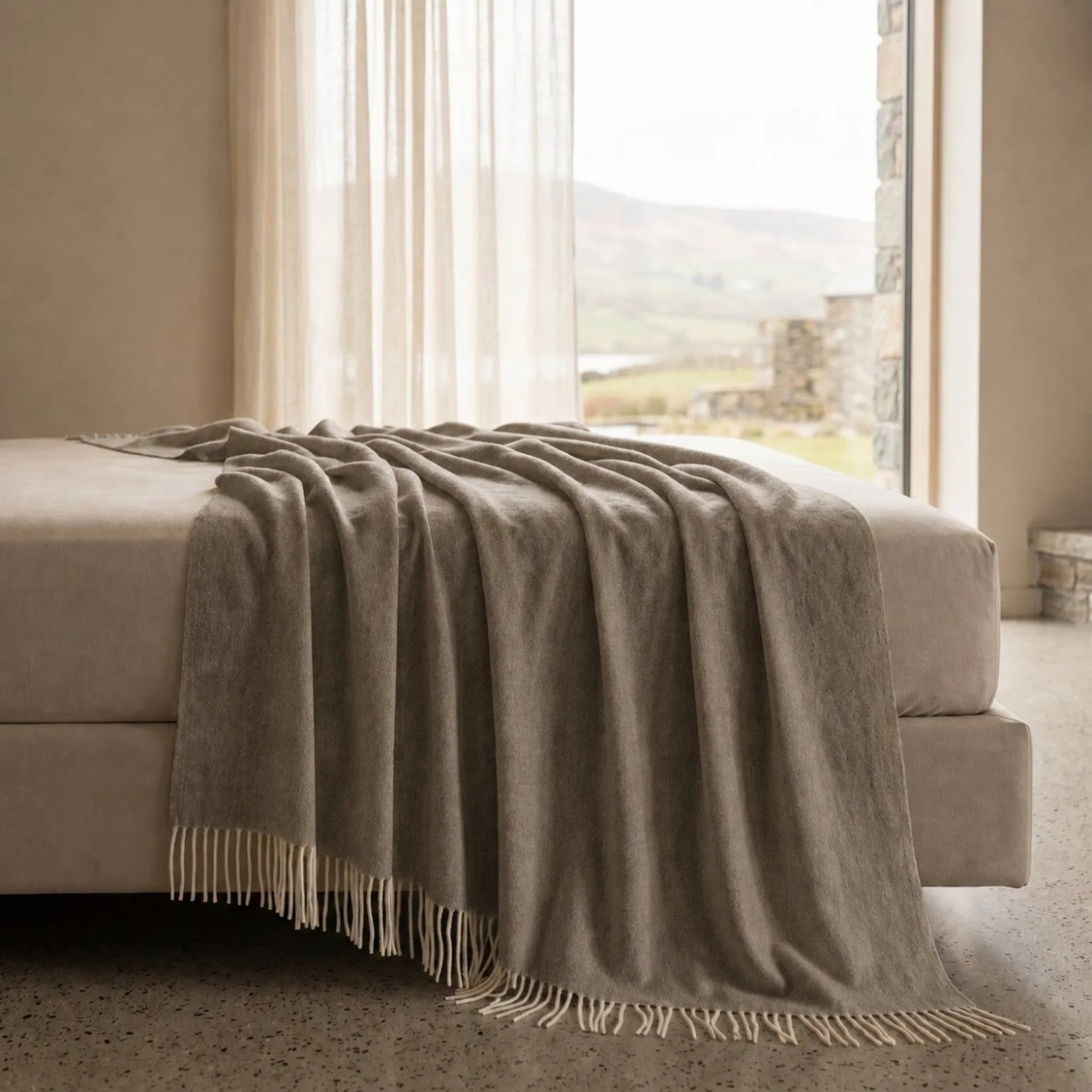 Taupe Baumwoll-Mix Sofadecke 130x170 cm mit Fransen, leicht und weich, auf einem Bett drapiert. Für Sofa & Bett.