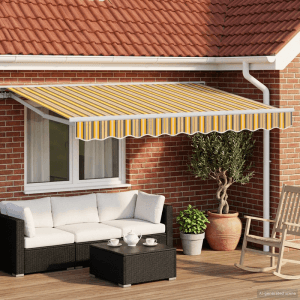 Elektrische Ausziehbare Markise in Gelb, Grau und Weiß gestreift. Bietet Sonnenschutz für Terrasse mit Outdoor-Möbeln.