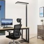 Moderne, dimmbare LED Bürostehleuchte Logan in Schwarz mit Bewegungsmelder am Schreibtisch.