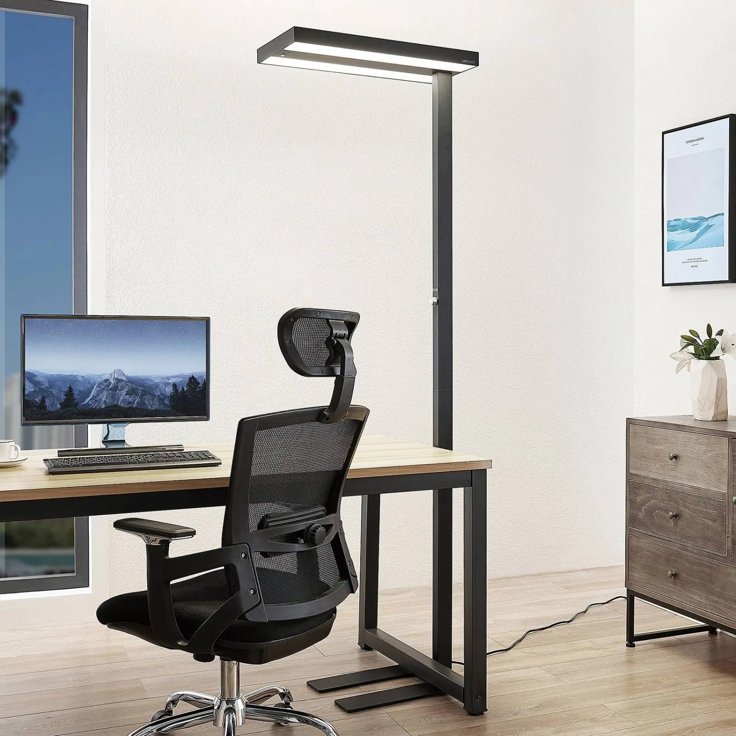 Moderne, dimmbare LED Bürostehleuchte Logan in Schwarz mit Bewegungsmelder am Schreibtisch.