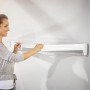 Frau bedient Leifheit Wandwäschetrockner Telegant 81 Protect Plus (Wäscheständer)