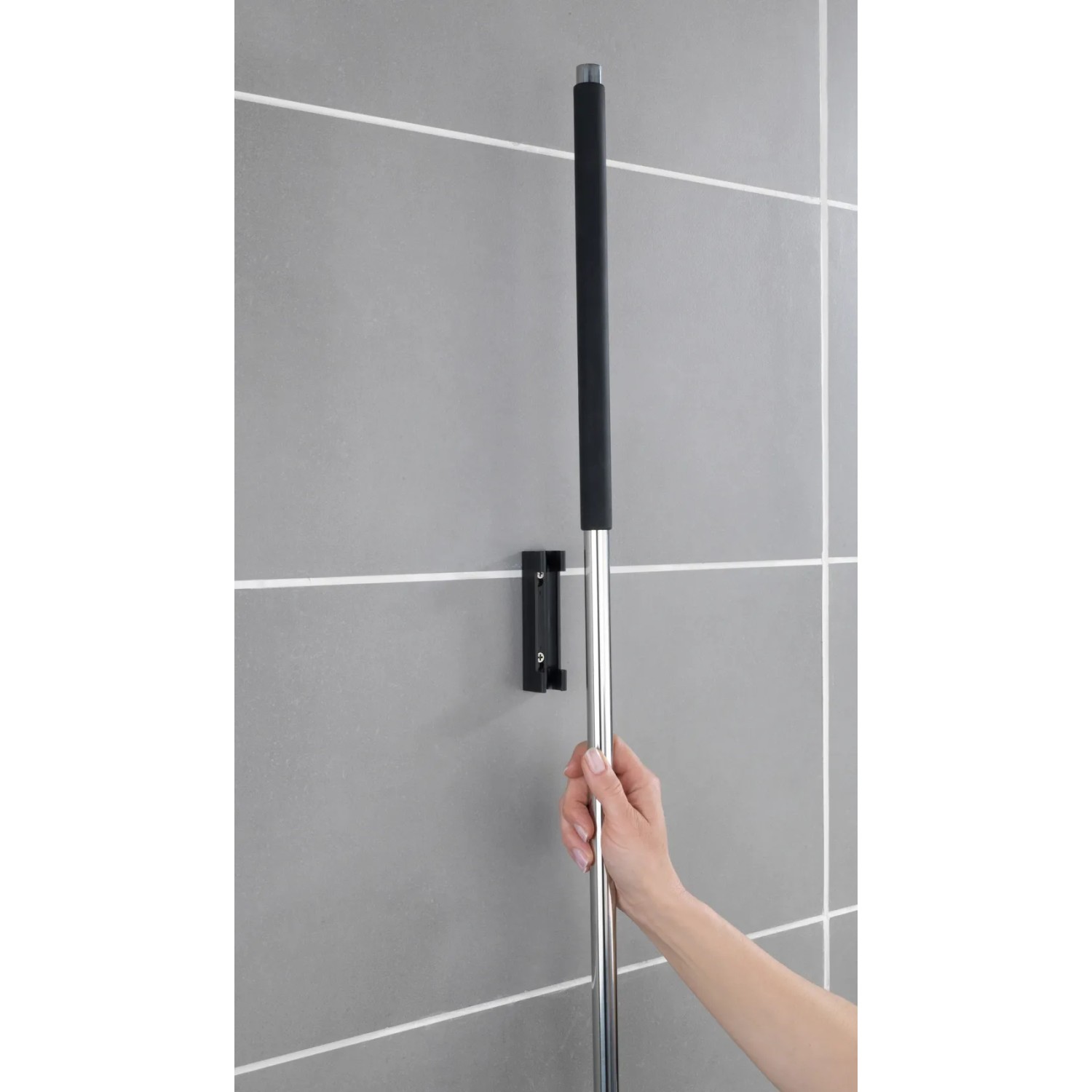 Wenko Edelstahl Boden- und Fensterwischer Rosole mit Wandhalterung an grauer Wand.