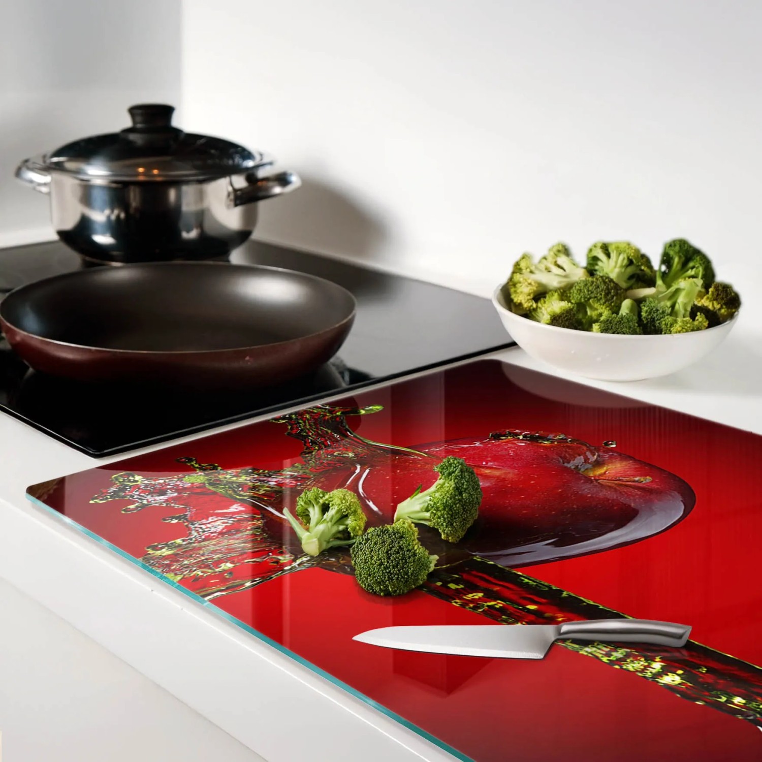 Glas-Herdabdeckplatte mit rotem Apfel-Wasser-Design, als Schneidebrett mit Brokkoli und Messer. 80x52 cm.