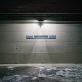Braune Mr. Beams LED-Außenwandleuchte mit Bewegungsmelder beleuchtet eine Garage.