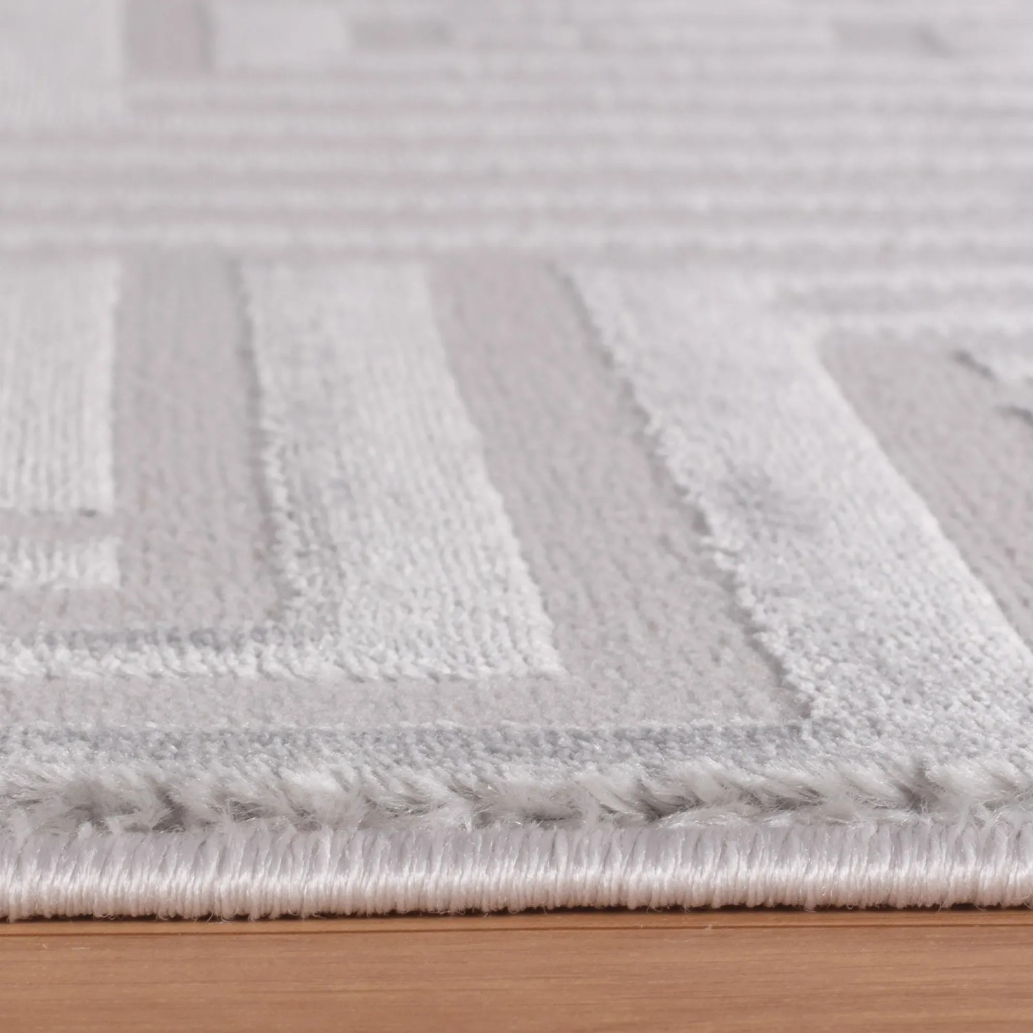 Detailansicht des silbernen Ayyildiz Kurzflorteppich Sahara mit geometrischem Muster.