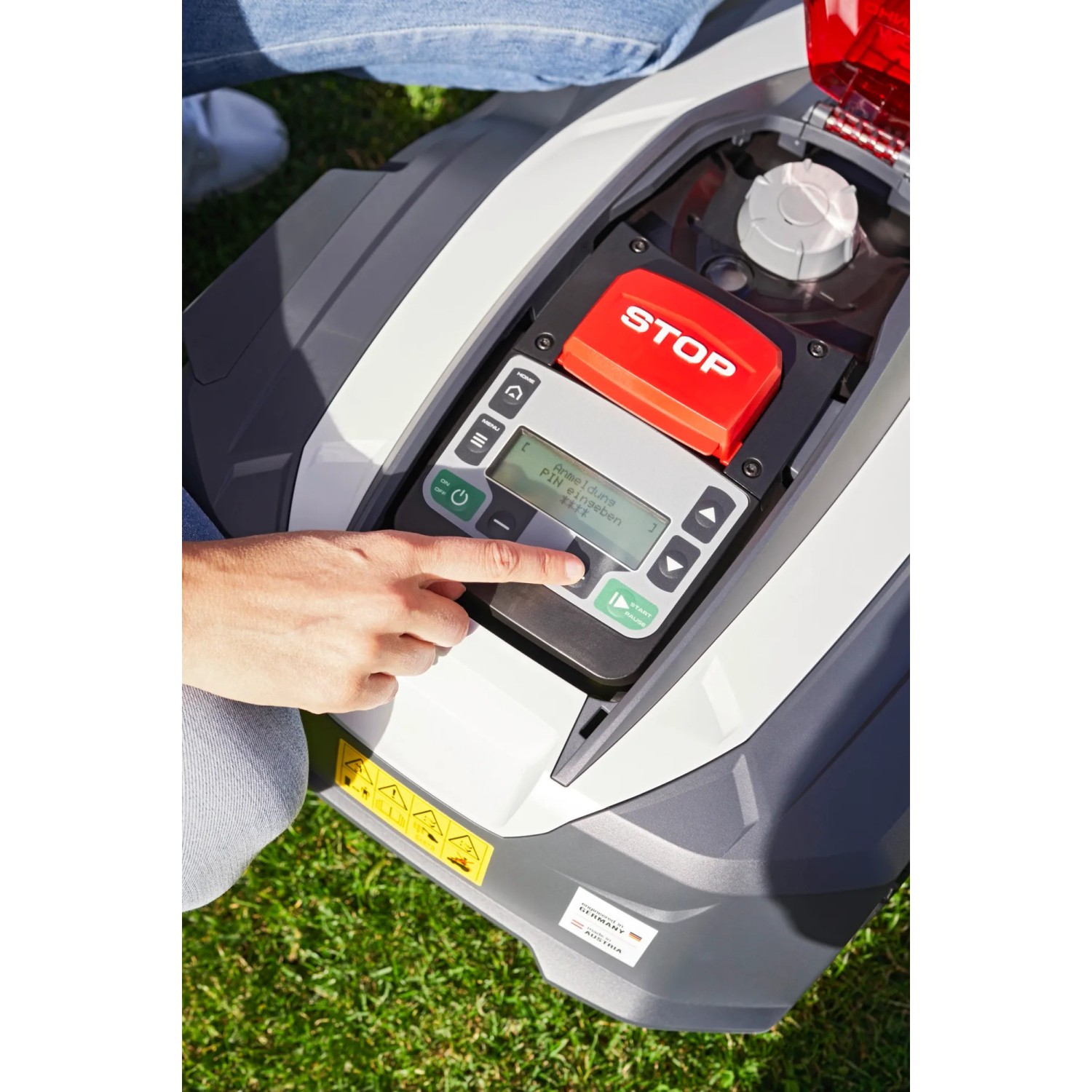 Al-Ko Robolinho 1.300 W Mähroboter: Bedienfeld mit Display und rotem Stopp-Knopf, Hand bedient Taste.