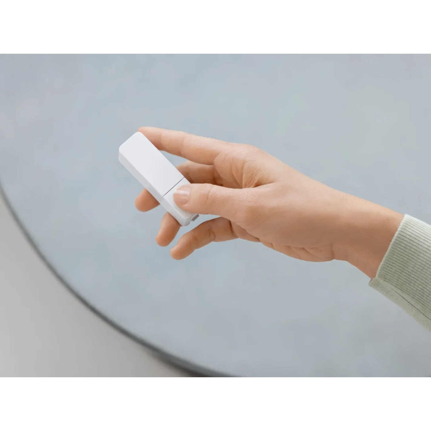Hand hält Bosch Smart Home Fenster-/Türsensor II Plus (weiß) für Hausautomation.