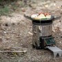 Petromax Raketenofen mit Grillplatte und Kochkreuz im Einsatz mit Grillgut.