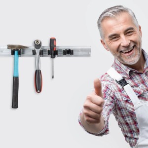 Mann lächelt, Daumen hoch, neben Relaxdays Gerätehalterleiste aus Aluminium mit Werkzeugen an weißer Wand. Ordnungssystem.