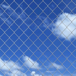 Verzinkter Maschendrahtzaun, 15x1,25 m, silbern, vor blauem Himmel.