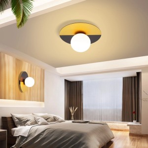 Schwarzgoldene Deckenleuchte mit rundem Metallgehäuse und weißem Glaskugelschirm im Schlafzimmer. E14 Fassung.