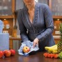 LUX Putztuch-Rolle in Anwendung: Frau reinigt Apfel mit Putztuch in Küche.