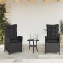 2 schwarze, verstellbare Gartensessel aus Poly Rattan mit Kissen, neben einem kleinen Tisch.