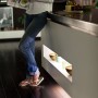 Frau liest neben Philips Hue Lightstrip Plus unter Kücheninsel. Ambientebeleuchtung.