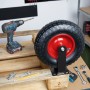 Schwarze, luftbereifte Bockrolle mit roter Felge und Stahl-Montageplatte auf Holzpalette. Ideal für Schwerlast-Transport.