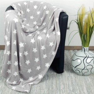 Hellgraue Bestlivings Kuscheldecke mit Sternenmuster auf einem Sessel. Ideal als Sofa- oder Bettüberwurf.