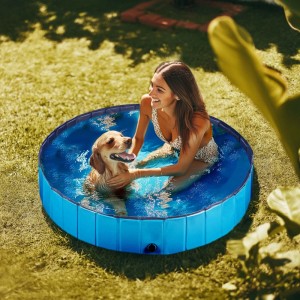 Frau und Hund im blauen Fudajo Hundepool 160x30 cm im Garten.