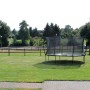 Grünes EXIT Silhouette Trampolin D305cm mit Sicherheitsnetz im Garten.