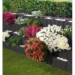 Anthrazitfarbene Wellino Pflanzsteine als dekorative, bepflanzte Hangbefestigung im Garten.