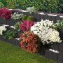 Anthrazitfarbene Wellino Pflanzsteine als dekorative, bepflanzte Hangbefestigung im Garten.