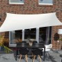 Rechteckiges, helles Sonnensegel über einer Terrasse mit Tisch und Stühlen. Sonnenschutz.
