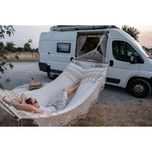 Person entspannt in Amazonas Hängematte Palacio Boho mit Stab vor Camper.