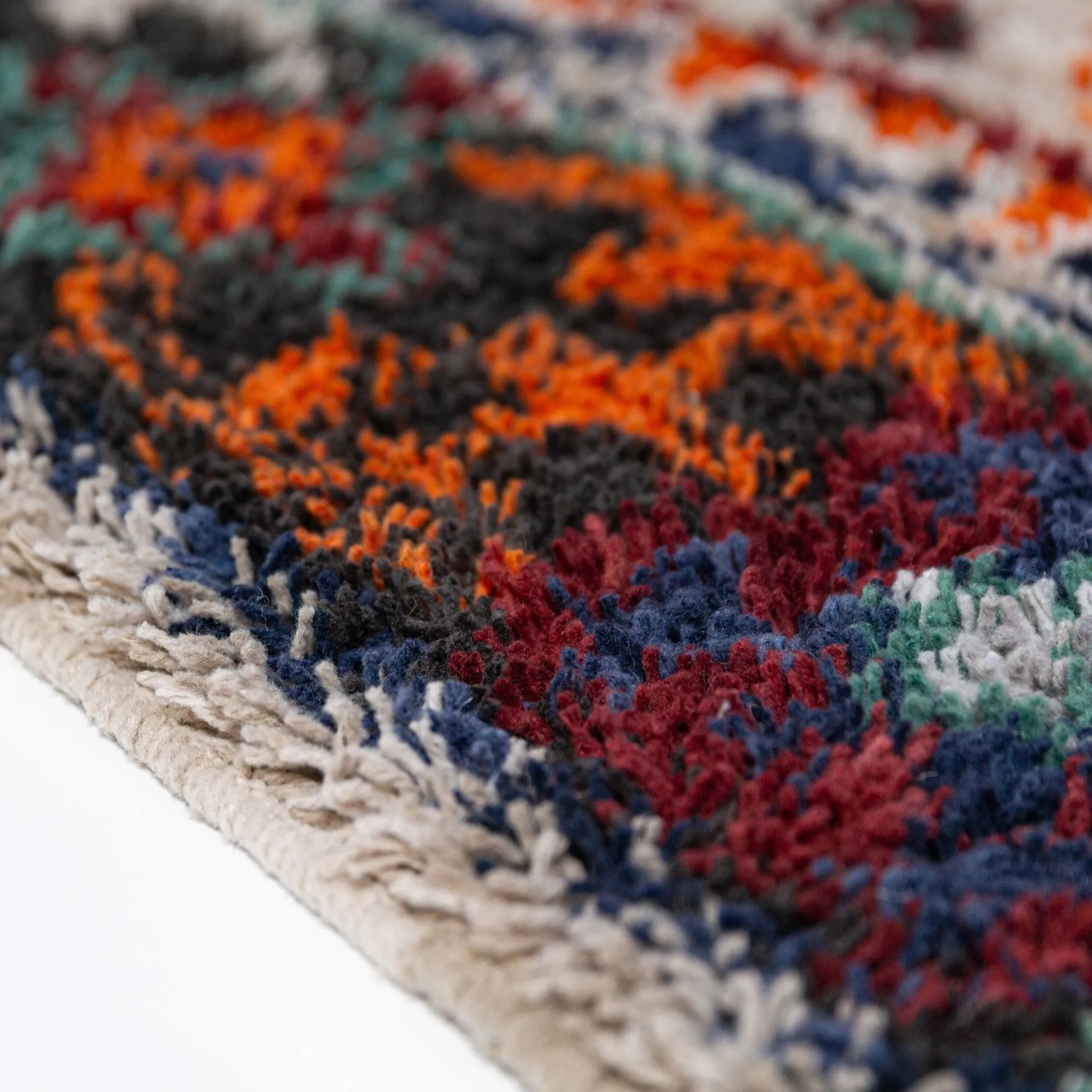 Flair Rugs Jakob Shaggy Hochflorteppich: Dichter, weicher Flor in Dunkelblau, Rot, Orange und Grau mit strukturiertem Muster.