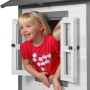 Kind im grauen Axi Lodge XL Spielhaus mit Fenster. Klassisches Spielhaus mit Rutsche.
