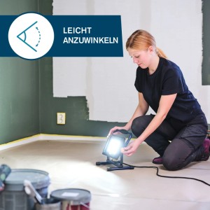 Frau justiert Rapid LED-Baustrahler The Painter+ bei Renovierungsarbeiten im Innenraum.