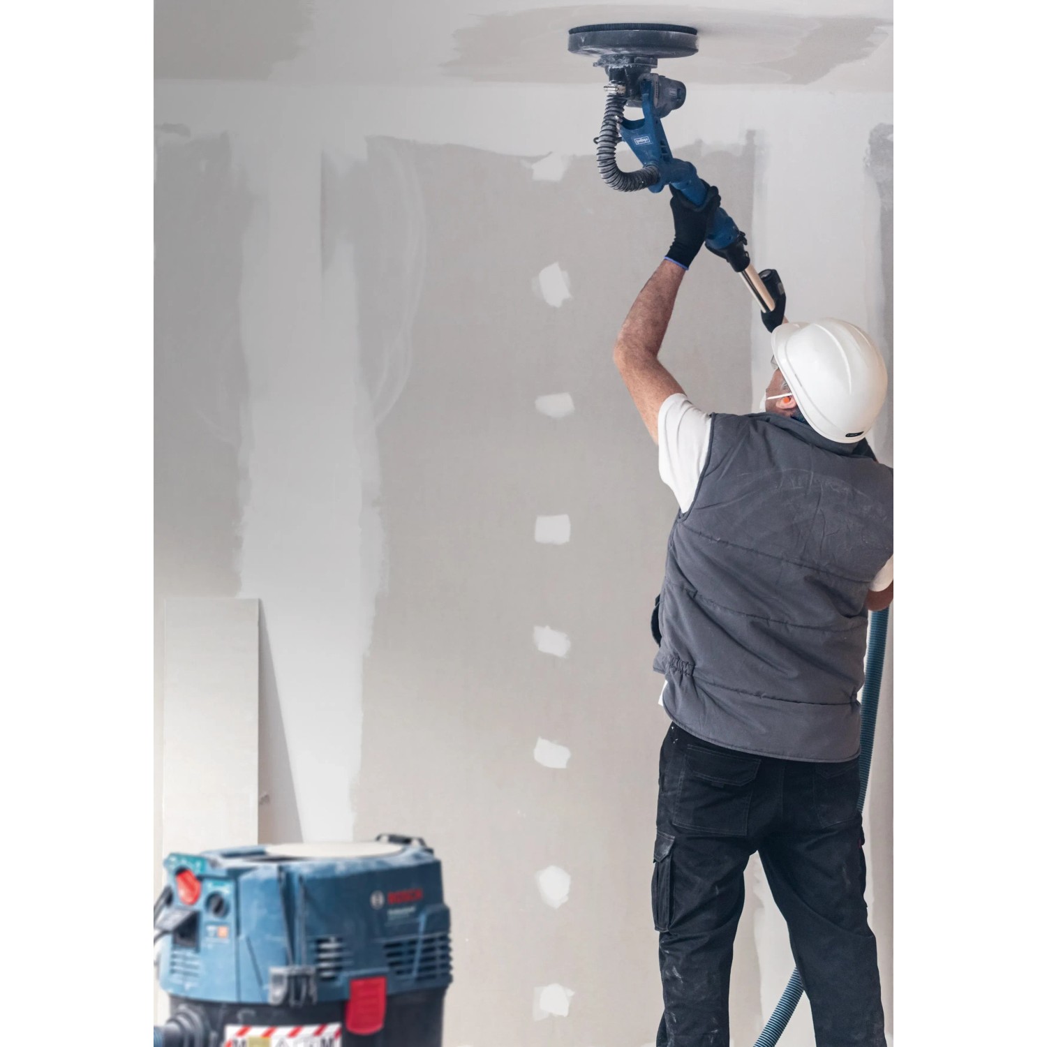 Bosch Expert M480 Netzschleifblatt mit Exzenterschleifer im Einsatz an einer Decke.