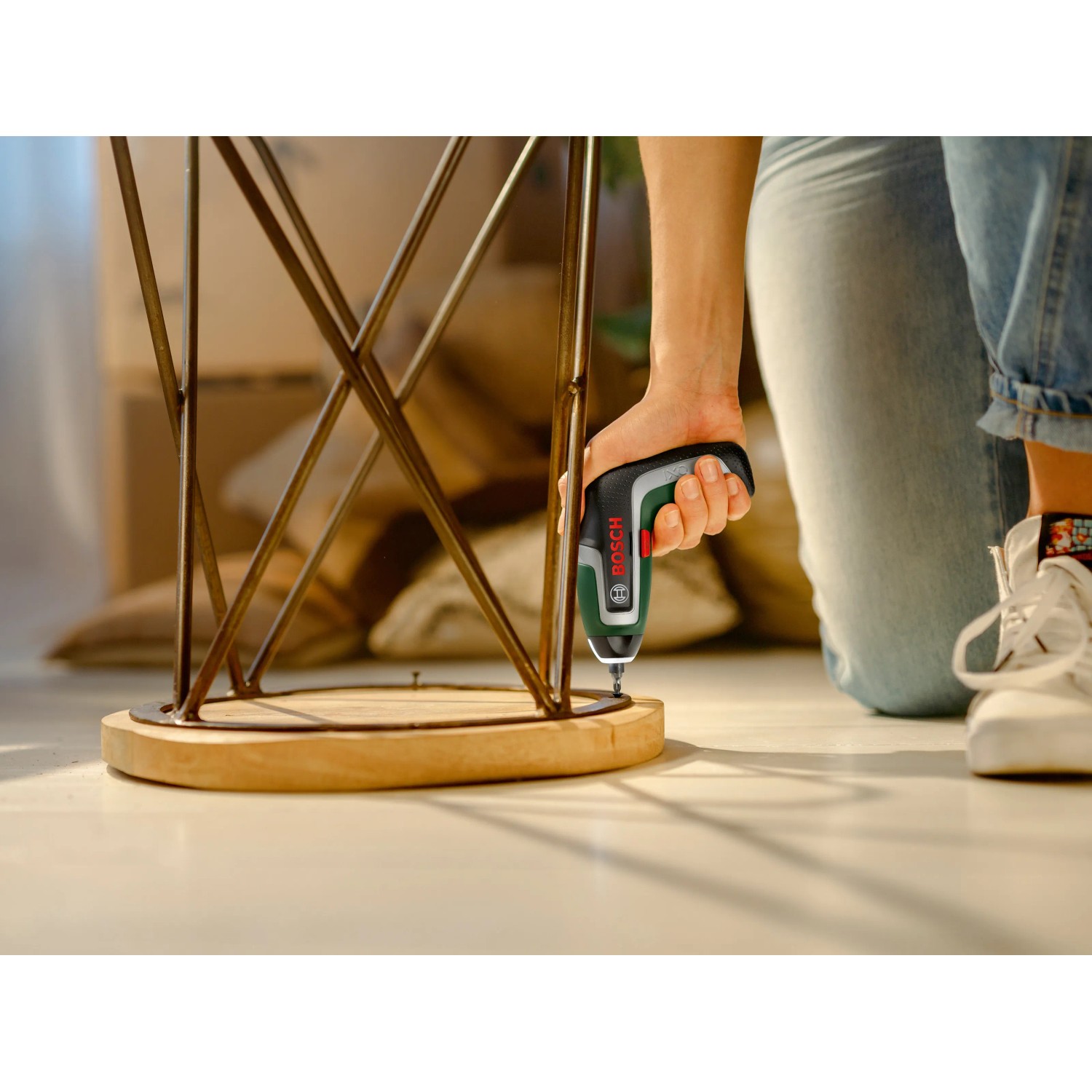 Bosch Akkuschrauber IXO 7 im Einsatz beim Schrauben an einem Tisch.