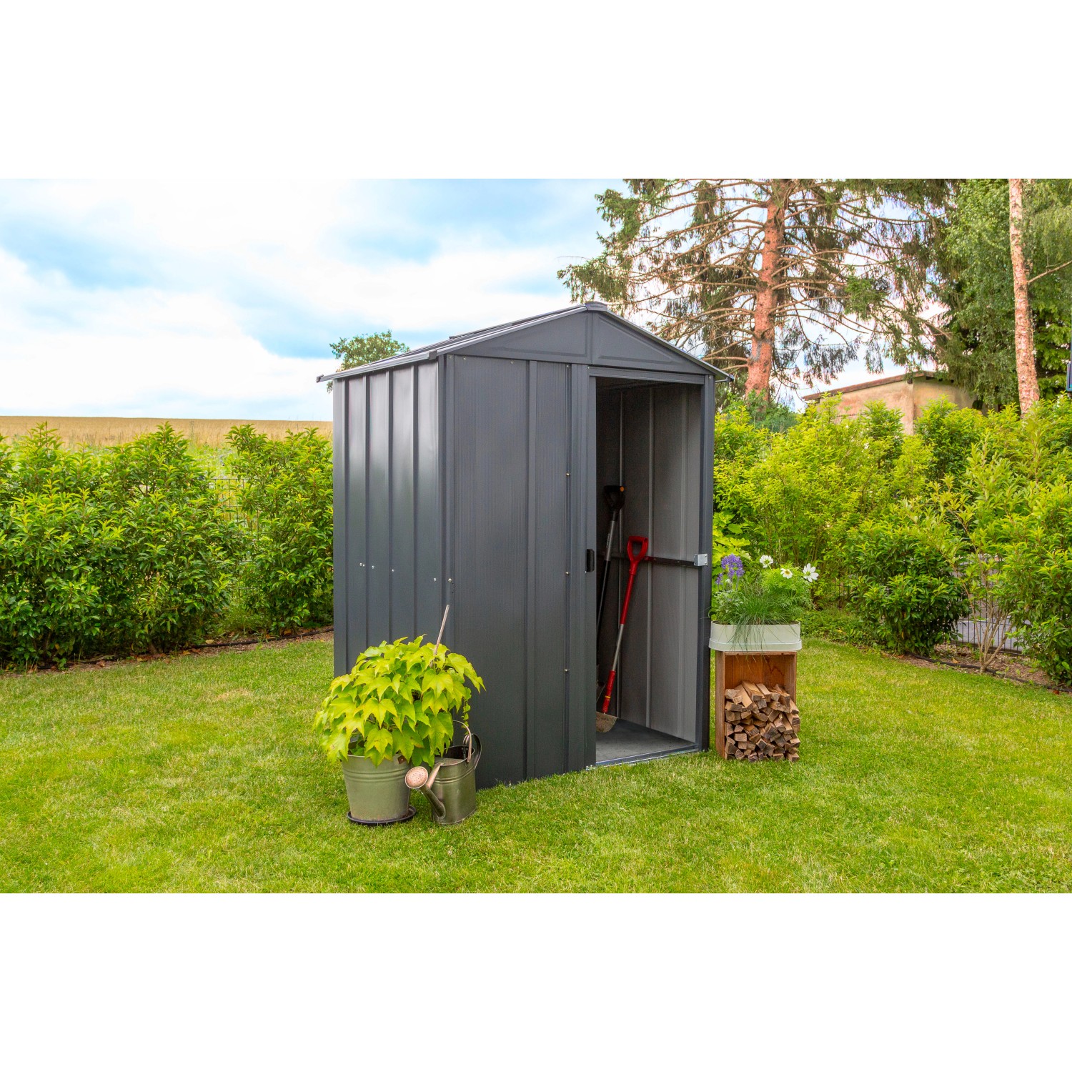 Spacemaker Metall-Gerätehaus, 1,5 m², grau, mit geöffneter Tür und Gartenzubehör im Garten.