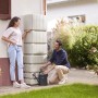 4rain Wandtank Slim 350 l Sandbeige mit zwei Personen im Garten.