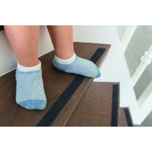 Abus Anti-Rutschband Zoe auf Treppe mit Kinderfüßen in Socken für mehr Sicherheit.