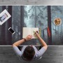 Graue Schreibtischunterlage mit Nebelwald-Motiv auf Schreibtisch, Person zeichnet. Schützt Arbeitsplatz, ideal für Bürobedarf.
