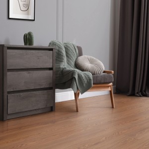 ML-Design Vinylboden Roteiche Braun, selbstklebend, im Wohnraum mit Kommode und Sessel.