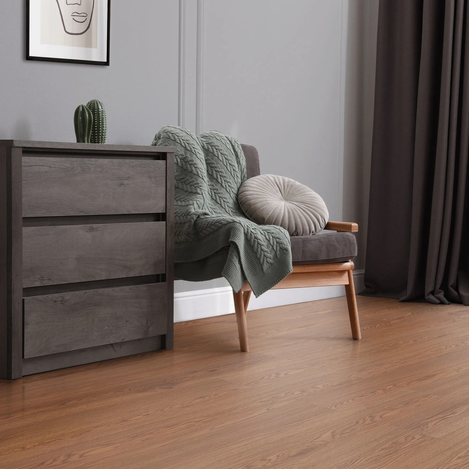ML-Design Vinylboden Roteiche Braun, selbstklebend, im Wohnraum mit Kommode und Sessel.