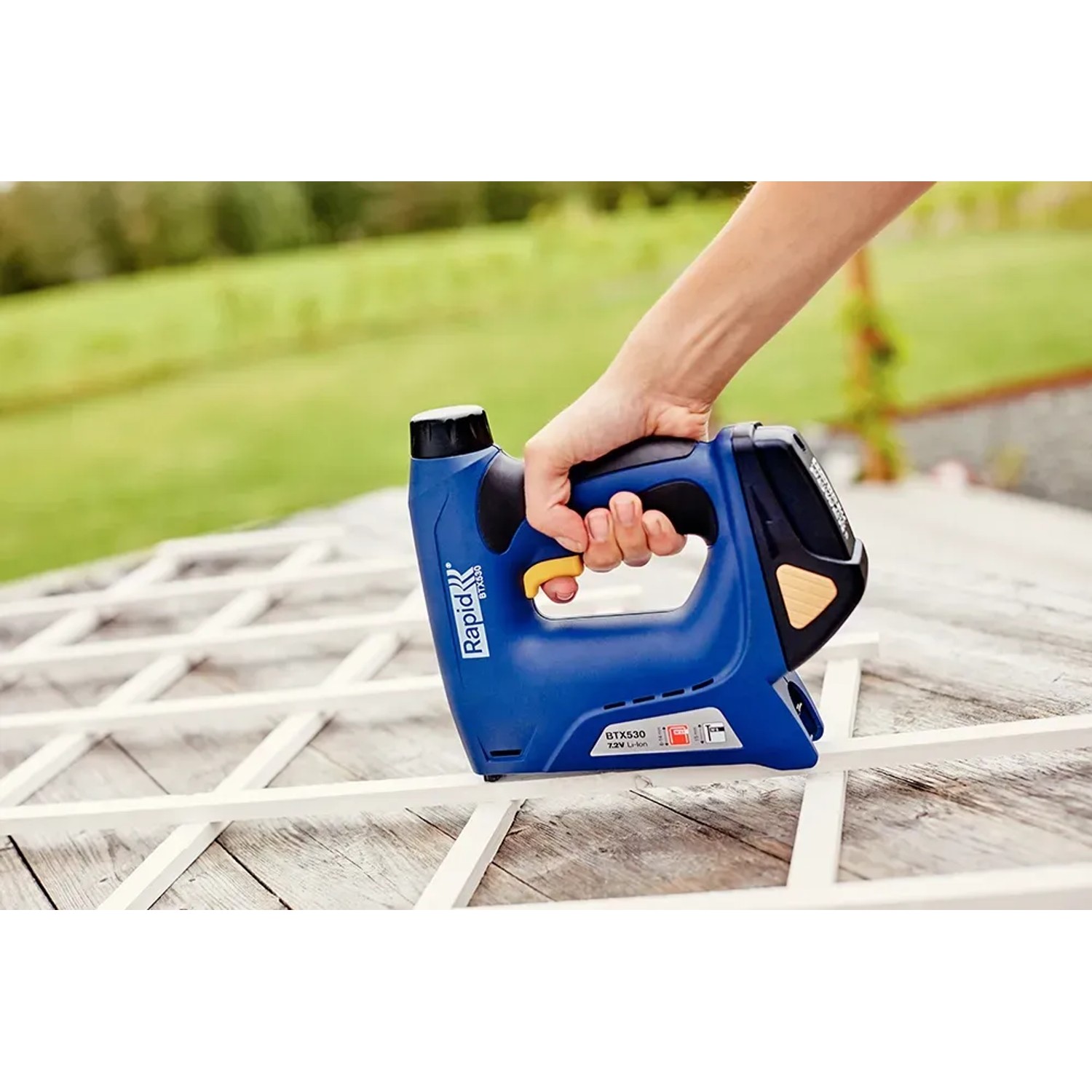 Rapid Akku-Tacker BTX530 in Aktion: Hand tackert Holzleiste. Ideal für Heimwerkerarbeiten.
