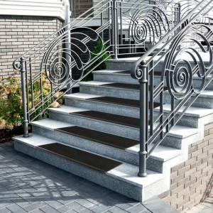 Schwarze Karat Gummi Stufenmatten Santiago auf Außentreppe mit Metallgeländer.