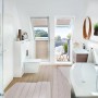 Helles Badezimmer mit Velux Dachbalkon-Türelement, das auf einen kleinen Balkon führt.