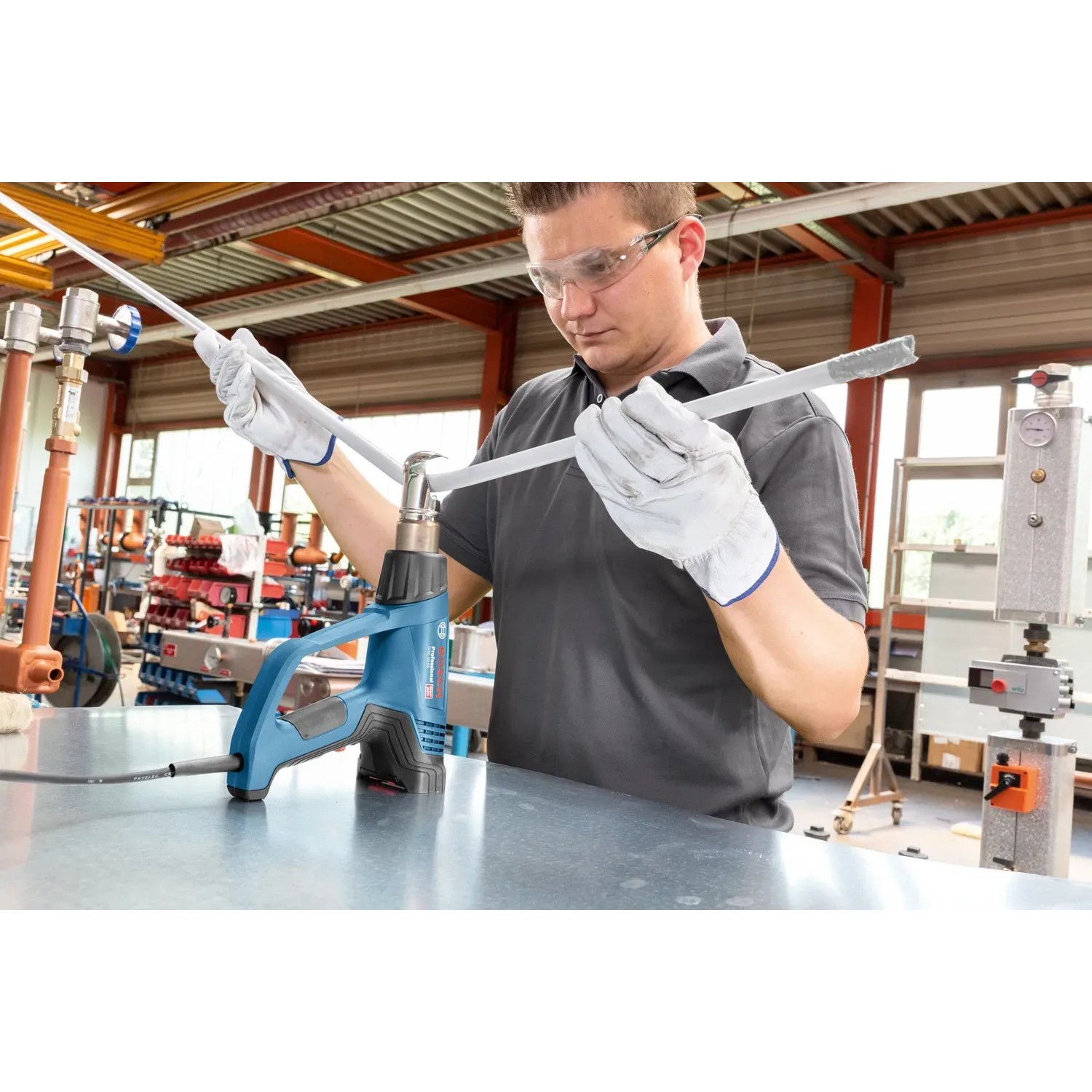 Bosch Professional Heißluftgebläse GHG 23-66 im Einsatz beim Erhitzen eines Rohrs.