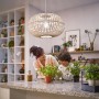 Philips LED E27 Lampe, 4W, klare Glühlampenform, neutralweißes Licht in Wohnraum mit Mutter und Kind.
