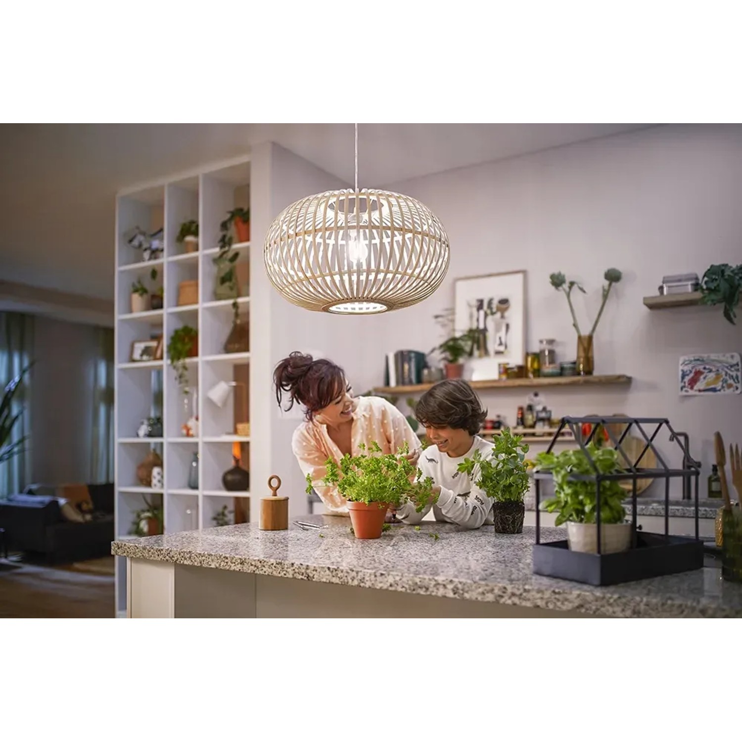 Philips LED E27 Lampe, 4W, klare Glühlampenform, neutralweißes Licht in Wohnraum mit Mutter und Kind.