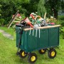 Dunkelgrüner Stahl-Gartenwagen mit gelben Rädern, beladen mit Gartengeräten, auf Rasen. Klappbarer Lastenwagen.