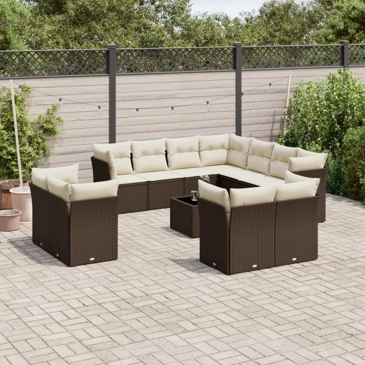 Braune 12-tlg. vidaXL Garten-Sofagarnitur aus Poly Rattan mit cremeweißen Kissen und Tisch auf einer Terrasse.