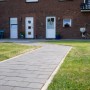 Anthrazitfarbener Diephaus Pflasterstein Mika (30x20x6 cm) als Gartenweg vor einem Haus.