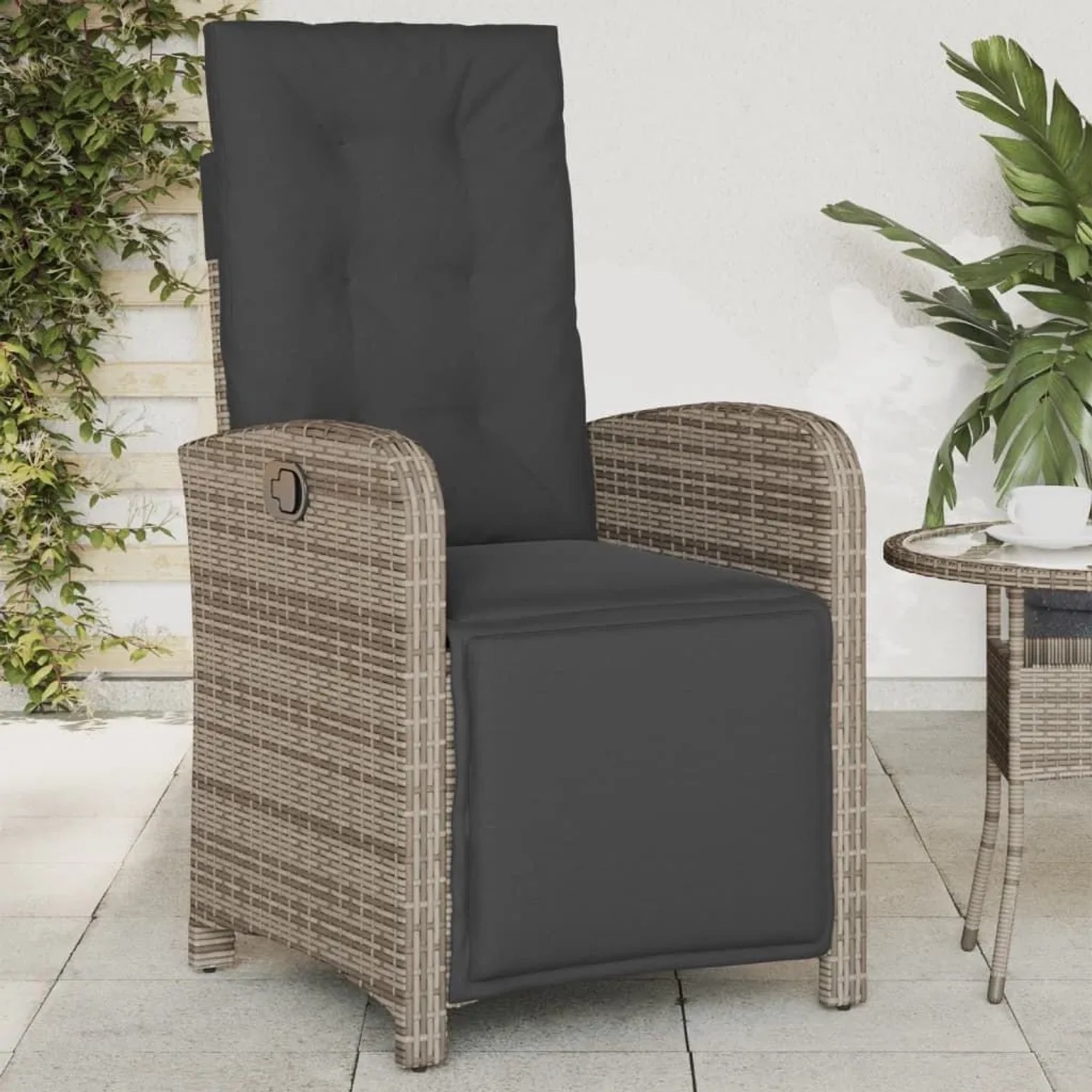 Verstellbarer Gartensessel mit Fußteil, grauem Polyrattan und dunklen Kissen.